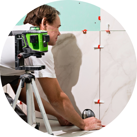 Laser level mounted on tripod projecting a red horizontal beam for precise alignment on a construction site