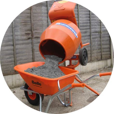 Orange Belle cement mixer pouring concrete into matching Belle wheelbarrow on a construction site with wooden fencing