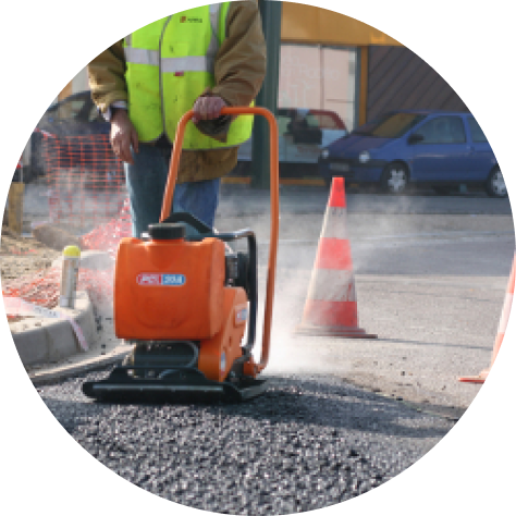 Plate compactor in operation compacting soil or gravel on a construction site, used for ground preparation before paving